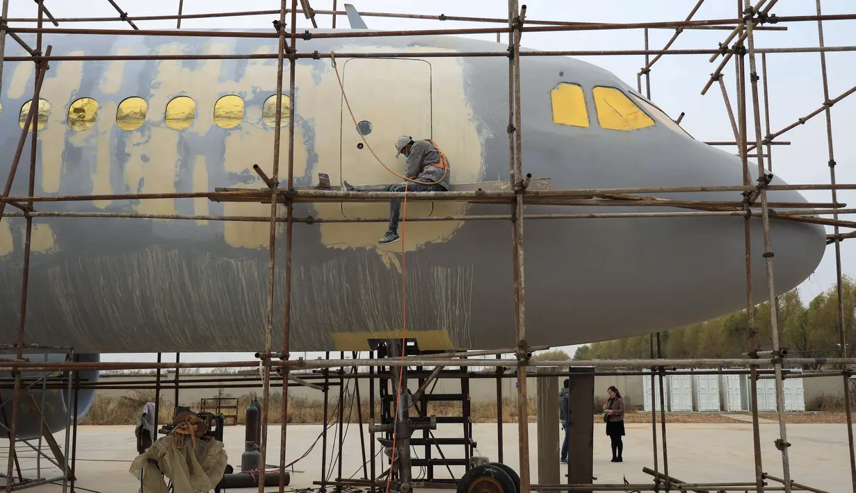 Seorang pria menyelesaikan replika pesawat Airbus A320 skala penuh di Kaiyuan, timur laut China, 25 Oktober 2018. Agar pembangunan pesawatnya ini mirip dengan yang asli, seorang petani bernama Zhu Yue berkiblat pada model mainan Airbus A320. (STR/AFP)