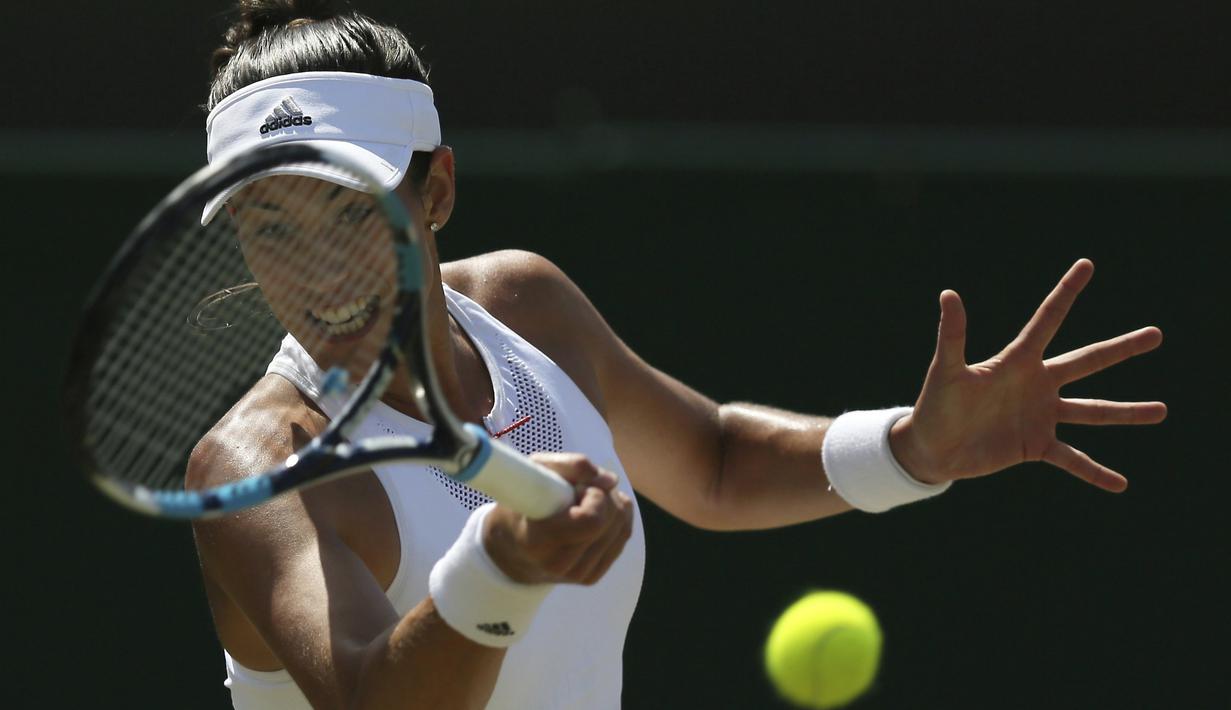 Aksi Garbine Muguruza mengembalikan bola kearah lawannya Angelique Kerber tunggal putri hari ketujuh di Wimbledon Tennis Championships, London, (10/7/2017). Garbine menang 4-6, 6-4, 6-4. (AP/Tim Ireland)