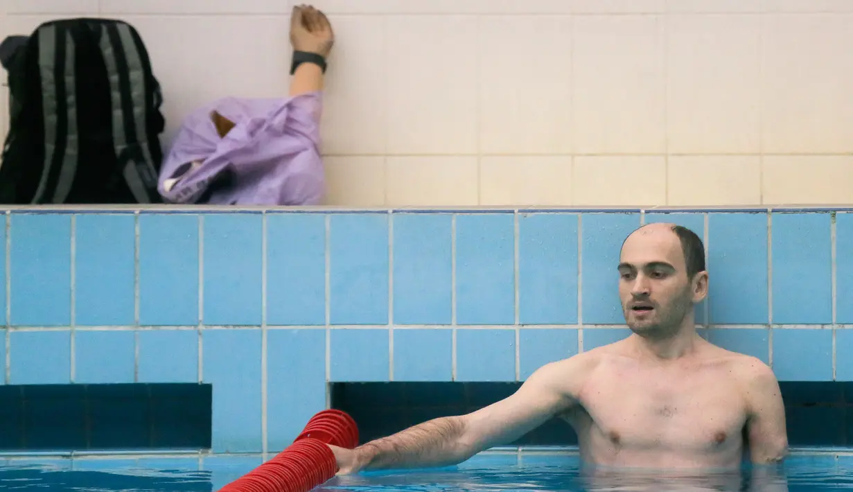 Seorang prajurit berendam di kolam dengan latar belakang tangan palsunya saat mengikuti tes untuk turnamen Invictus Games Ukraine di Kiev, Ukraina (28/1). (AP Photo/Efrem Lukatsky)