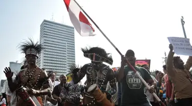 Masyarakat Papua yang merupakan mantan karyawan PT Freeport Indonesia saat melakukan penggalangan dana di tengah berlangsungnya Hari Bebas Kendaraan Bermotor atau Car Free Day di kawasan Bundaran HI, Jakarta, Minggu (5/8). (Merdeka.com/Iqbal S. Nugroho)