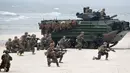 Pasukan marinir AS bersenjata lengkap melakukan operasi pendaratan saat latihan militer Baltops 2018 di Laut Baltik, Lithuania (4/6). (AP/Mindaugas Kulbis)