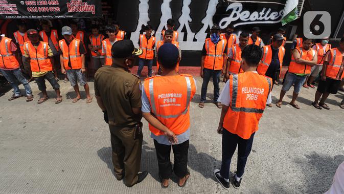 Puluhan pelanggar PSBB dikumpulkan saat razia masker di Pasar Reni, Pamulang, Tangerang Selatan, Banten, Selasa (1/9/2020). Razia terhadap pedagang dan pengunjung pasar ini juga dilakukan rapid test guna mencegah penularan COVID-19. (merdeka.com/Arie Basuki)