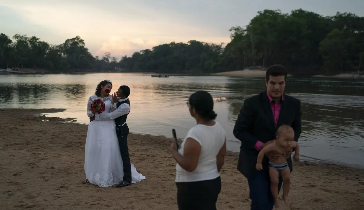 Gislaine Pereira de Araujo berpose untuk foto untuk album pernikahan bersama suaminya Ronilson de Araujo Souza dengan latar belakang hutan hujan Amazon di pantai sungai Jamanxim, di Novo Progresso, Brasil (2/9/2019). (AP Photo/Leo Correa)