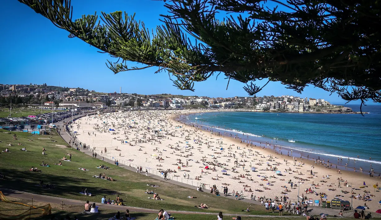 Orang-orang mengunjungi pantai Bondi di Sydney, Australia pada 5 Oktober 2020. Kerumunan warga dan aktivitas yang ramai ini membuat penerapan jarak sosial menjadi nyaris mustahil dilakukan.  (Photo by DAVID GRAY / AFP)