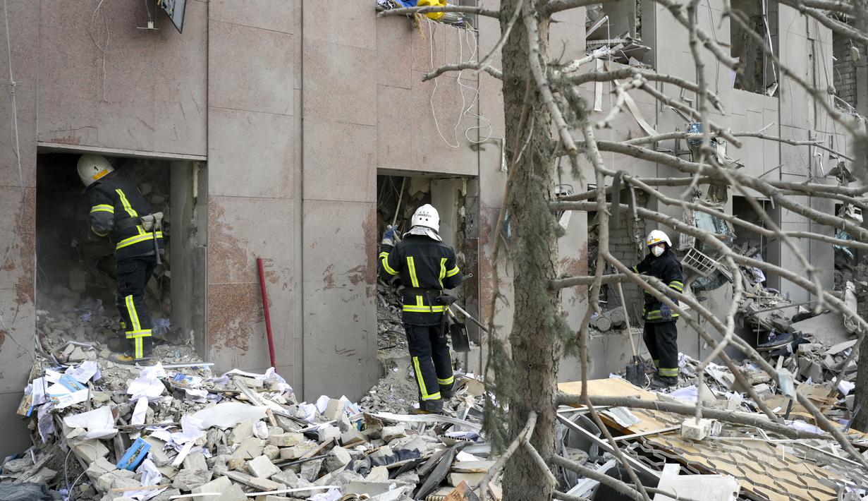 Petugas pemadam kebakaran membersihkan puing-puing gedung pemerintah yang terkena roket Rusia di Mykolaiv (29/3/2022). Gubernur Vitaly Kim mengatakan bahwa kebanyakan orang di dalam gedung tidak terluka tetapi beberapa warga sipil dan tentara belum ditemukan. (AFP/Bulent Kilic)