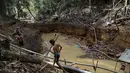 Suku Yanomami indian melihat kondisi hutan yang rusak akibat pertambangan emas ilegal di jantung Hutan Amazon, Roraima, Brasil, pada 18 April 2016. Padahal tempat ini menjadi rumah bagi ribuan orang suku Yanomami. ( REUTERS / Bruno Kelly) 