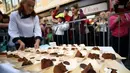 Potongan kue cokelat raksasa atau dikenal sebagai Sacher Torte, yang akan dibagikan kepada pejalan kaki di Ljubljana, Slovenia, Rabu (21/9). Kue cokelat tersebut menghabiskan 2.000 butir telur, 80 kg selai, dan 200 kg cokelat. (AFP PHOTO/Jure MAKOVEC)
