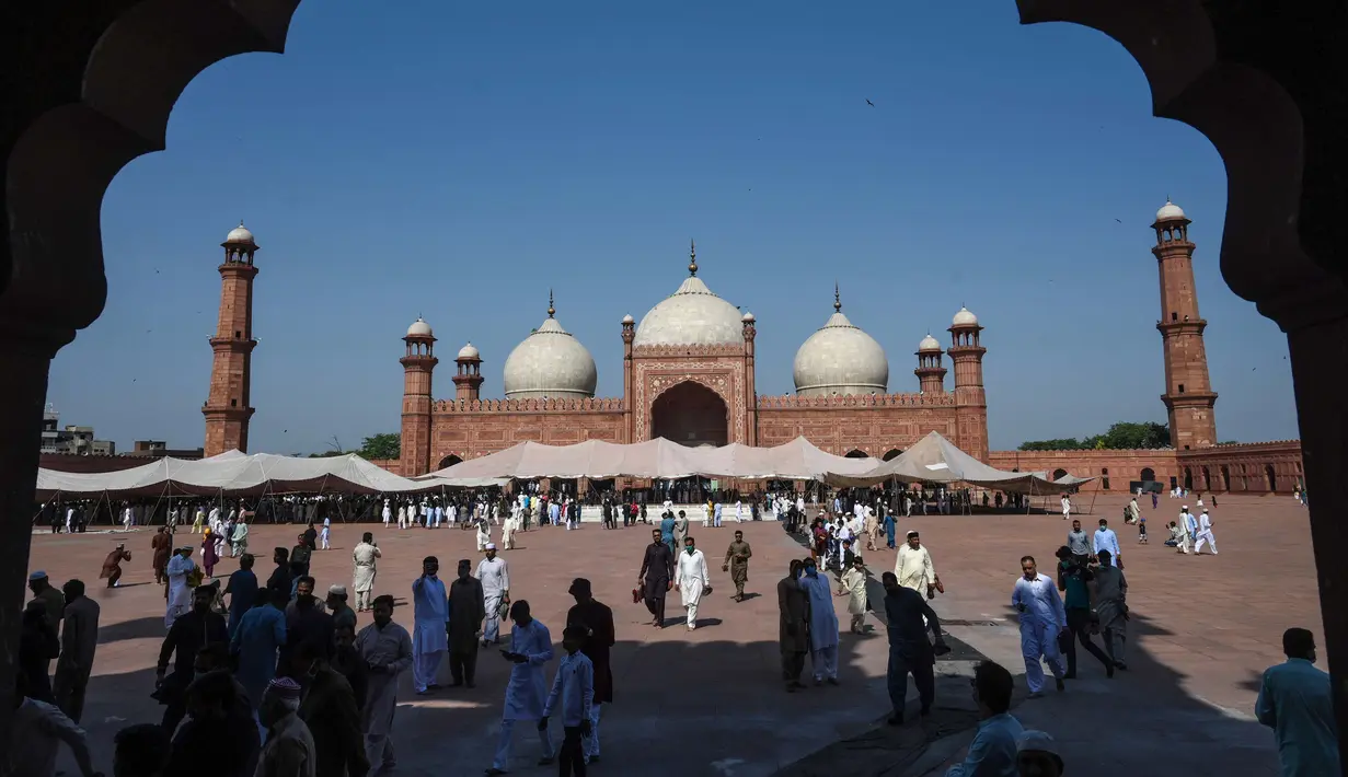 Umat Islam Pakistan setelah selesai melaksanakan salat  Idul Fitri di Masjid Badshahi di Lahore pada 24 Mei 2020. Umat Muslim di seluruh dunia mulai menandai Idul Fitri yang suram di tengah pembatasan akibat corona Covid-19 . (Photo by Arif ALI / AFP)