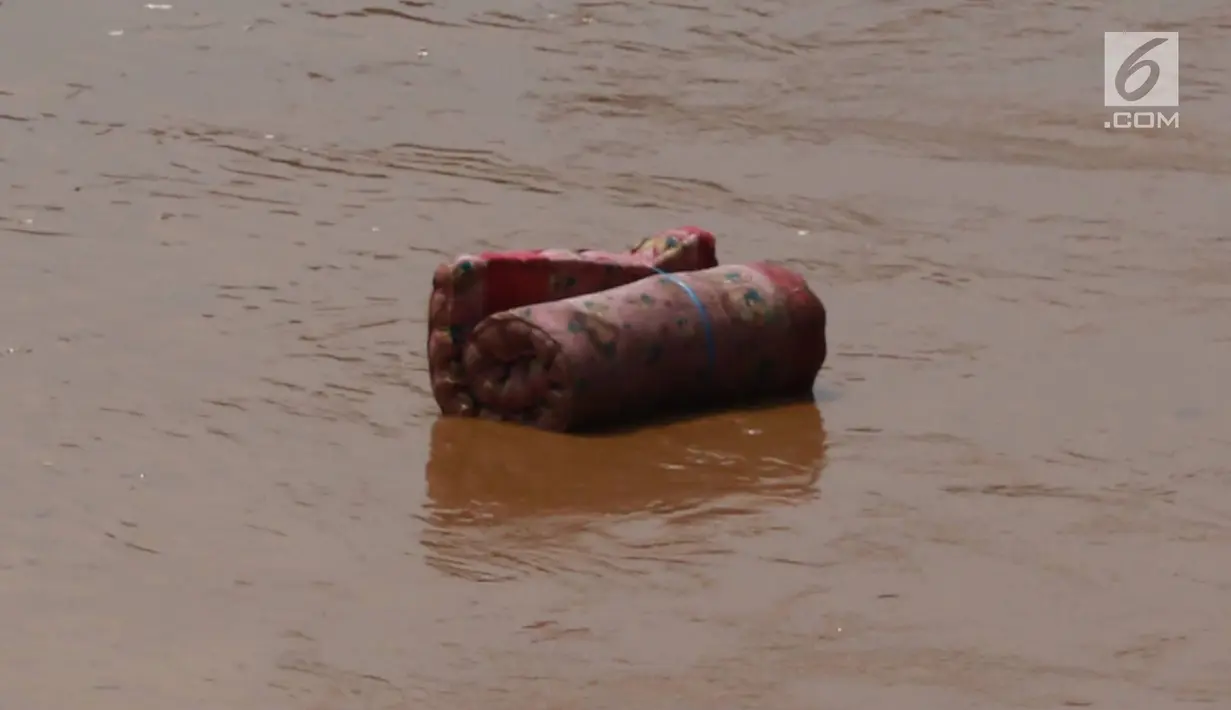 Sebuah kasur menghanyut di aliran Sungai Ciliwung yang meluap di kawasan Pejaten Timur, Jakarta, Jumat (26/4). Banjir kiriman melalui Sungai Ciliwung yang berasal dari Bogor tersebut mengakibatkan sejumah wilayah di Ibukota terendam banjir. (Liputan6.com/Immanuel Antonius)