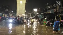 Sejumlah pengendara sepeda motor menunggu banjir surut yang menggenangi kawasan Simpang Seskoal, Kebayoran Lama, Jakarta, Sabtu malam (16/2). Banjir setinggi 50cm - 1 meter hanya bisa dilalui bus atau kendaraan berukuran besar. (Liputan6.com/Septian)