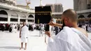 Jemaah berpose di depan Ka'bah selama umrah di Masjidil Haram, Makkah, Arab Saudi, Senin (2/3/2020).  Kementerian Kesehatan Arab Saudi telah mengumukan pada Senin 2 Maret 2020 telah menemukan adanya kasus Virus Corona pertama warga negara Saudi yang kembali dari Iran melalui Bahrain. (AP Photo/Amr N