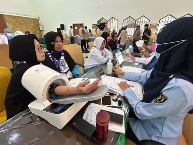 Petugas memeriksa kesehatan calon haji setibanya di Asrama Haji Pondok Gede, Jakarta, Selasa (21/4/2026). Sebanyak 393 jemaah haji kelompok terbang (kloter) pertama embarkasi Jakarta-Pondok Gede (JKG 01) secara resmi mulai memasuki Asrama Haji Pondok Gede, Jakarta Timur. (merdeka.com/Arie Basuki)