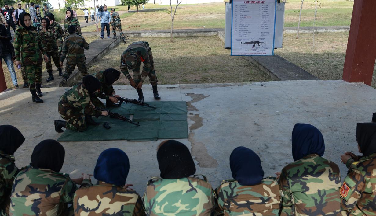 Sejumlah kadet tentara wanita Afghanistan memperhatikan pengarahan pelatih yang mengajarkan cara menyiapkan senapan sebelum menembak saat mengikuti program latihan militer di Akademi Pelatihan Perwira di Chennai, India (12/12/2019). (AFP/Arun Sankar)