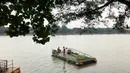 Petugas kebersihan mengumpulkan sampah di Perkampungan Budaya Betawi Setu Babakan, Jakarta, Senin (22/6/2020). Danau buatan seluas 30 hektare tersebut kembali dibuka untuk umum setelah sebelumnya ditutup untuk mencegah penyebaran virus corona COVID-19. (Liputan6.com/Immanuel Antonius)