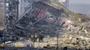 Orang-orang memeriksa kerusakan setelah serangan sebuah pusat perbelanjaan di Kiev, Ukraina, Senin (21/3/2022). Delapan orang tewas dalam serangan tersebut. (AP Photo/Efrem Lukatsky)