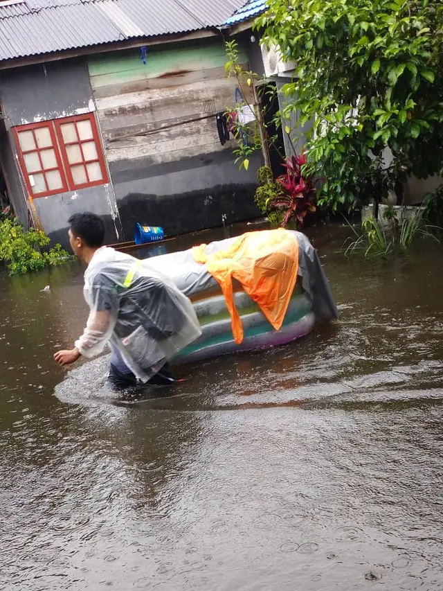 potret upaya penyelamatan orang tua terhadap anak di tengah banjir