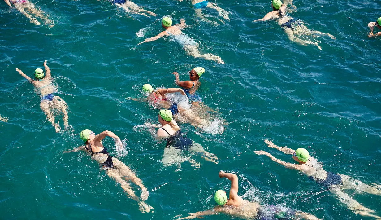 Aksi ratusan peserta menyeberangi Danau Zurich saat berpartisipasi dalam perhelatan tahunan di Swiss, 5 Juli 2017. Dalam ajang tersebut, ribuan orang harus bersaing mengarungi Danau Zurich sejauh 1,5 kilometer. (AFP PHOTO / Michael Buholzer)