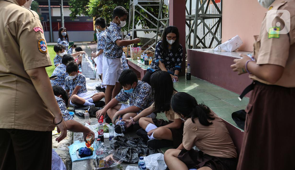 Siswa mengikuti kegiatan belajar mengajar secara tatap muka di luar ruangan saat PPKM level 1 di SD Pangudi Luhur, Jakarta, Rabu (25/5/2022). Pemerintah pusat menerapkan Pemberlakuan Pembatasan Kegiatan Masyarakat (PPKM) level 1 untuk wilayah aglomerasi Jakarta, Bogor, Depok, Tangerang, dan Bekasi (Jabodetabek) selama dua pekan, terhitung sejak 24 Mei. (Liputan6.com/Johan Tallo)