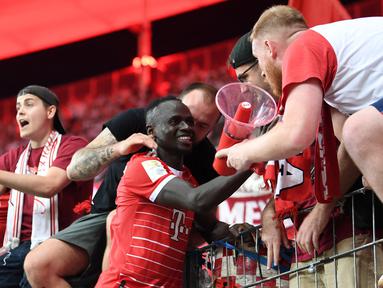 Para penggemar Bayern Munchen nampaknya tak mau berlama-lama larut dalam kesedihan usai ditinggal mesin gol mereka yakni, Robert Lewandowski yang hijrah ke Barcelona. Mereka nampaknya sudah mendapatkan pahlawan baru bagi Die Rotten yaitu Sadio Mane yang akan membawa Munchen ke jalur juara musim ini. (AFP/Christof Stache)