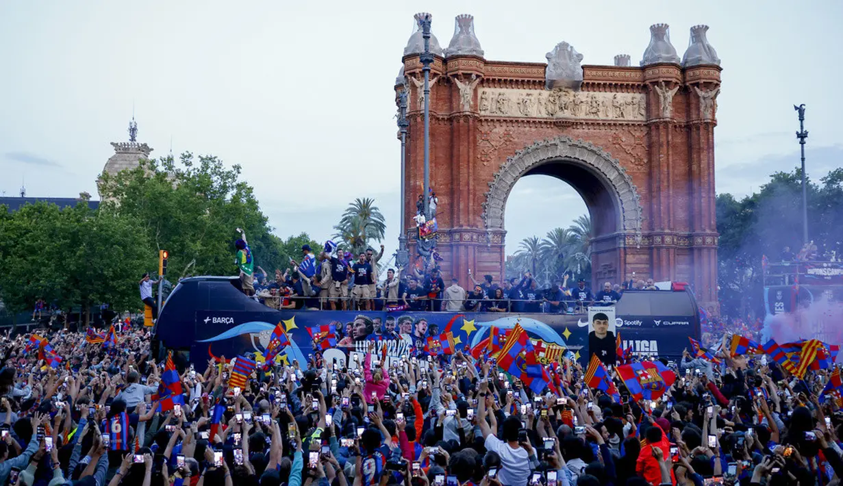 <p>Barcelona menggelar parade kemenangan dengan bus atap terbuka untuk merayakan gelar juara Liga Spanyol 2022/2023.&nbsp;(AP Photo/Joan Monfort)</p>
