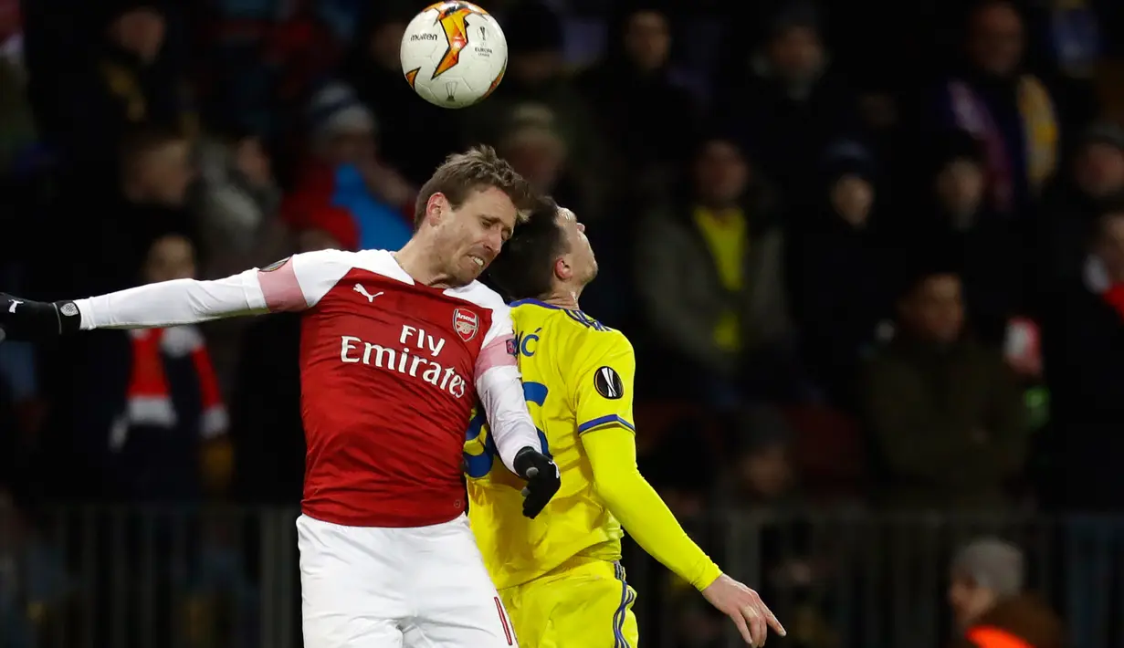 Duel udara bek Arsenal, Nacho Monreal dengan pemain BATE Borisov, Nemanja Milic pada leg pertama 32 besar Liga Europa di Borisov Arena, Kamis (14/2). Arsenal kalah dengan skor 0-1 saat bertandang ke markas Bate Borisov. (AP/Sergei Grits)