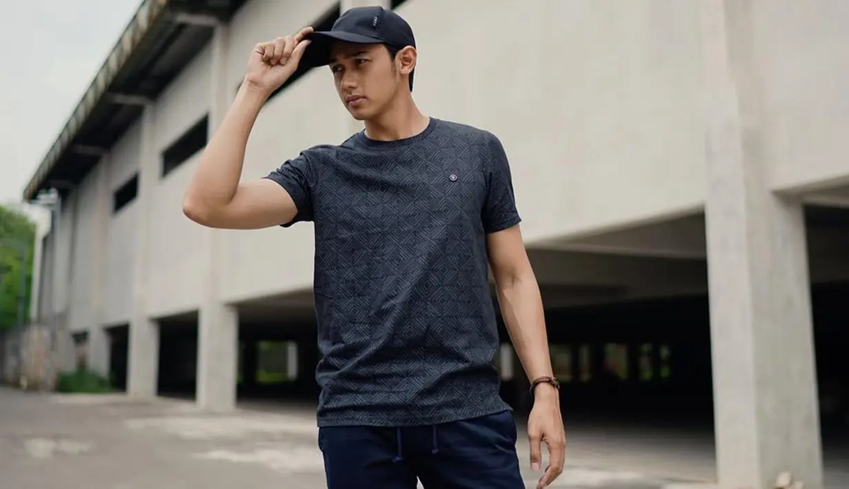 Ia cukup sering mengenakan busana berwarna gelap. Penampilan pesinetron Cinta Karena Cinta ini juga terlihat santai dnegan mengenakan kaus dan topi berwarna abu-abu yang dipadukan dengan aksesoris gelang di salah satu tangannya. (Liputan6.com/IG/@hitocaesar)