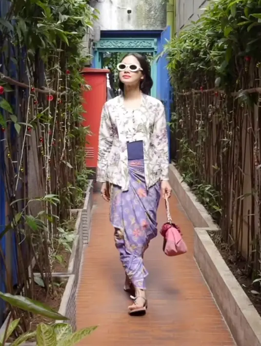 Andien Aisyah mengenakan kebaya kutu baru bercorak floral dipadukan obi ungu serasi dengan kain batik sebagai bawahannya. [@andienaisyah]