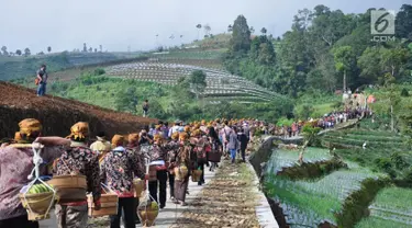 Warga membawa tenongan menuju makam sesepuh mereka saat mengikuti Sadranan Rejeban Plabengan di Lereng Gunung Sumbing, Temanggung, Jawa Tengah, Jumat (22/3). Dalam tradisi ini warga menggelar doa dan makan bersama di makam sesepuh. (Liputan6.com/Gholib)