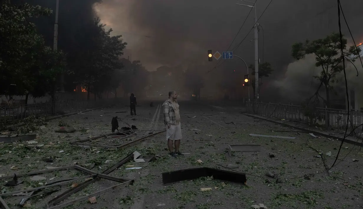 Seorang pria berdiri di tengah kepulan asap dan melihat bangunan-bangunan yang rusak parah akibat serangan Rusia di Kyiv pada Minggu 24 Mei 2026, di tengah invasi Rusia ke Ukraina. (Roman PILIPEY/AFP)