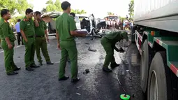 Petugas memeriksa lokasi kecelakaan sebuah van yang membawa rombongan pengantin dengan truk kontainer di Quang Nam, Vietnam, Senin (30/7). 14 orang dalam satu keluarga termasuk pengantin pria tewas seketika. (Do Van Truong/Vietnam News Agency via AP)