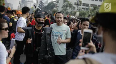 Warga berfoto dengan para peserta parade seni budaya Kepulauan Nias saat Car Free Day di Kawasan Jalan Sudirman, Jakarta, Minggu (4/3). (Liputan6.com/Faizal Fanani)