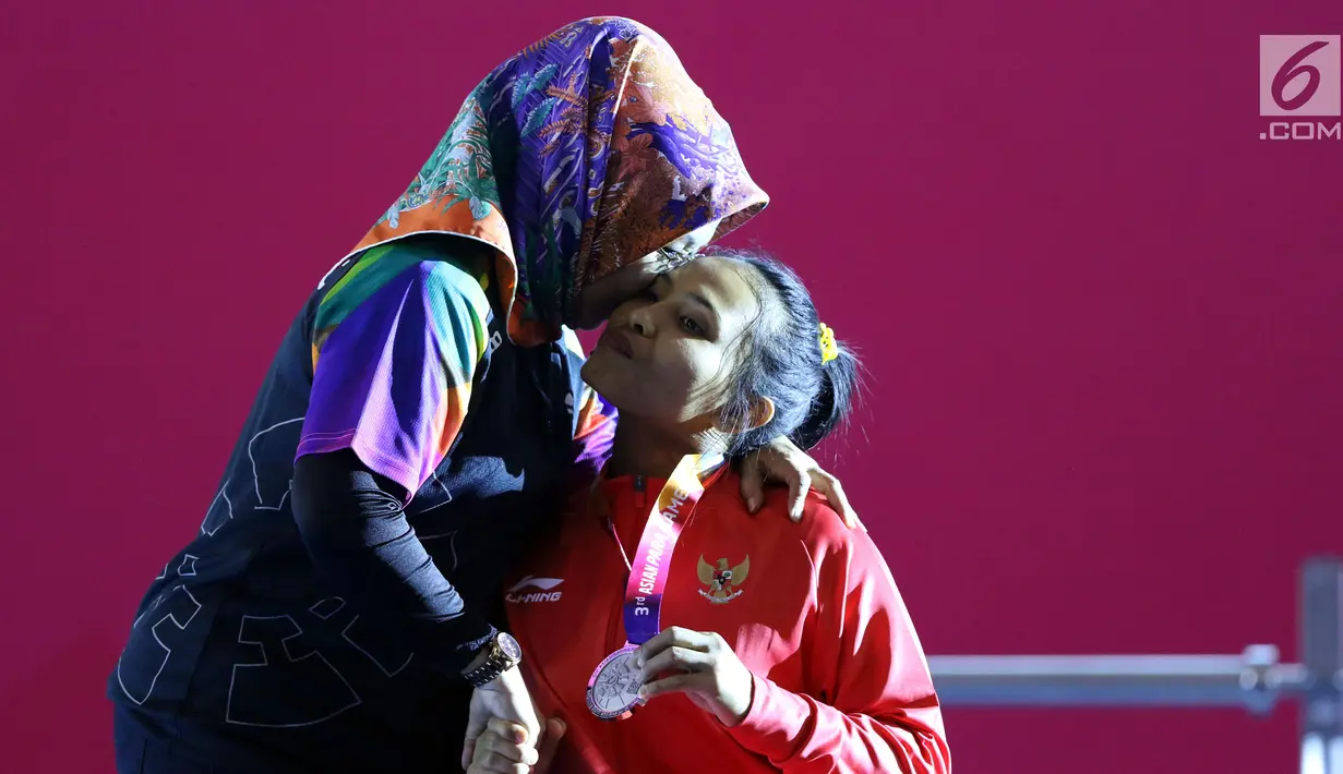 Atlet Para Powerlifting Indonesia, Ni Nengah Widiasih (kanan) saat prosesi medali Womens Up to 41.00kg Asian Para Games 2018 di Jakarta, Minggu (7/10). Ni Nengah Widiasih berhasil melakukan total angkatan 97 kg. (Liputan6.com/Helmi Fithriansyah)