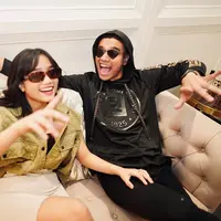 Dalam foto ini, terlihat keduanya mengenakan busana yang serasi. Fuji dengan double breasted waistcoat berkerah dengan nuansaa hijau, sedangkan Fadly tampak mengenakan hoodie hitam. Keduanya juga kompak mengenakan sunglasses. Foto: Instagram.