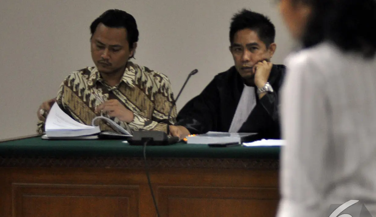 Anak mantan Menteri Syarief Hasan, Riefan Avrian, terlihat membaca berkas saat menjalani sidang lanjutan kasus dugaan korupsi proyek videotron dengan agenda mendengarkan keterangan saksi, Jakarta, Kamis (30/10/2014). (Liputan6.com/Miftahul Hayat)