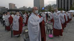 Para biksu mengenakan masker saat merayakan ulang tahun Buddha di Gwanghwamun Plaza, Seoul, Korea Selatan, Kamis (30/4/2020). Ulang tahun Buddha kali ini dirayakan di tengah pandemi virus corona COVID-19. (AP Photo/Ahn Young-joon)