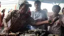Wagub DKI Jakarta, Djarot Saiful Hidayat (baju putih) memilih kepiting saat blusukan ke Pasar Petak Sembilan, Jakarta, Sabtu (18/6). Selain berbincang-bincang Djarot juga memborong sejumlah sayuran yang dijual para pedagang. (Liputan6.com/Helmi Afandi)