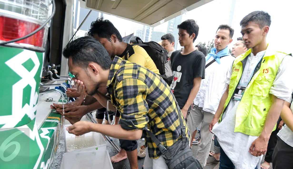 Demonstran memanfaatkan mobil masjid untuk mengambil air wudhu sebelum salat Jumat bersama di Bundaran Patung Kuda, Jakarta, Jumat (4/11). Sebagian massa demonstan gelar salat Jumat di area Bundaran Patung Kuda. (Liputan6.com/Yoppy Renato)