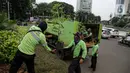 Petugas Dinas Pertamanan dan Hutan DKI Jakarta menurunkan bunga matahari dari truk di Bundaran HI, Jakarta, Jumat (18/6/2021). Pemasangan bunga matahari di kawasan Bundaran HI dalam rangka menyambut HUT ke-494 DKI Jakarta sekaligus mempercantik kawasan tersebut. (Liputan6.com/Faizal Fanani)