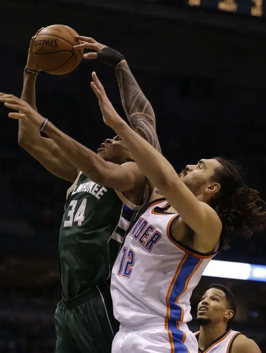 Pemain Milwaukee Bucks, Giannis Antetokounmpo #34 melakukan tembakan saat dihadang pemain Oklahoma City Thunder, Steven Adams pada laga NBA di Bradley Center, (2/1/2017). Bucks menang 98-94. (AP/Jeffrey Phelps)