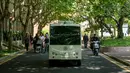 Minibus tanpa awak membawa penumpang berjalan di Shanghai Jiao Tong University di Shanghai, China (8/5). Penumpang bisa memesan untuk menaiki bus ini dengan cara memindai kode melalui ponsel pintar mereka. (AFP Photo/China Out)