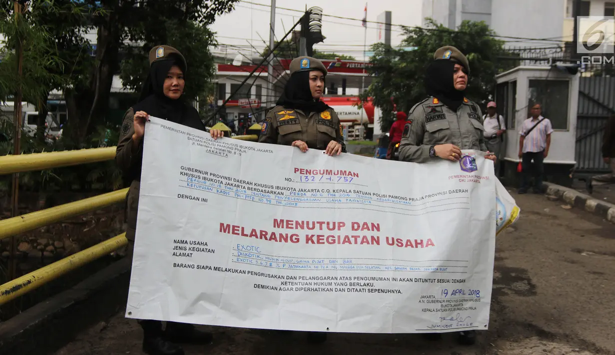 Petugas Satpol PP wanita membawa spanduk penutup saat akan menyegel Diskotek Exotic di Mangga Besar, Jakarta, Kamis (19/4). Segala kegiatan yang berada di dalam Diskotek Exotic pun dinyatakan terlarang alias ilegal. (Liputan6.com/Arya Manggala)
