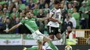 Gelandang Irlandia Utara, Stuart Dallas, berusaha menekel gelandang Jerman, Serge Gnabry, pada laga Kualifikasi Piala Eropa 2020 di Windsor Park, Belfast, Senin (9/9). Irlandia Utara kalah 0-2 dari Jerman. (AFP/Paul Faith)