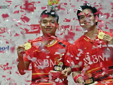 Ganda putra Indonesia, Leo Rolly Carnando (kiri) dan Daniel Marthin berpose di podium kemenangan setelah mengalahkan Kim Astrup dan Anders Skaarup Rasmussen dari Denmark pada final turnamen bulu tangkis Indonesia Masters di Jakarta, 28 Januari 2024. (ADEK BERRY/AFP)
