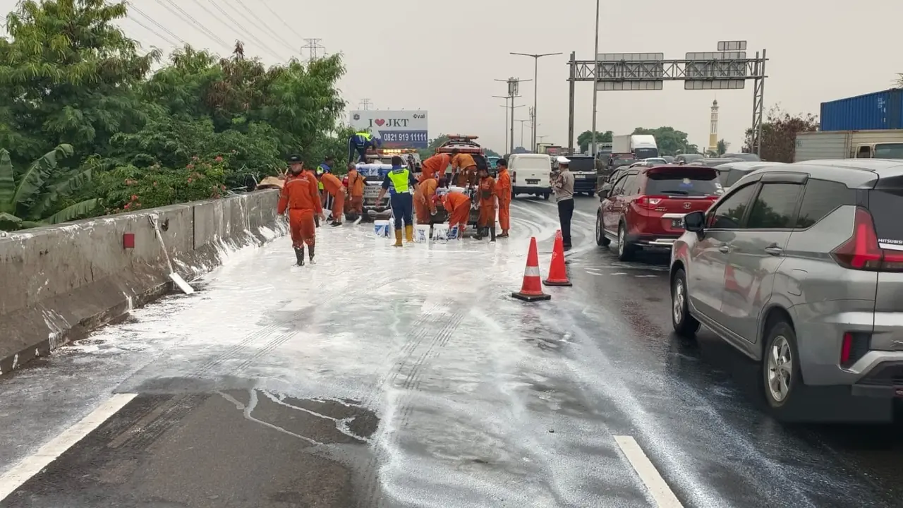 Tumpahan cak terlihat  di ruas Tol Pluit arah Tanjung Priok, Kamis (11/9/2025), akibat truk muatan tersebut mengalami kecelakaan.