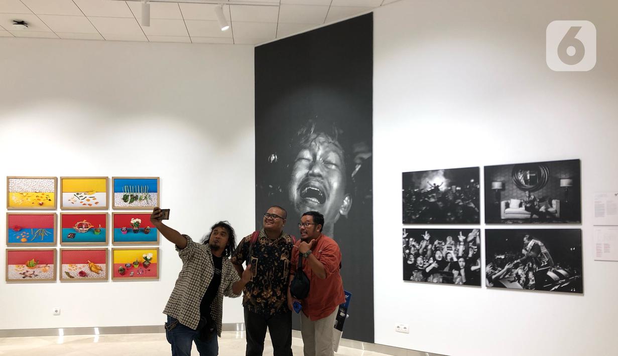 Salah satu pameris, Rivan Awal Lingga (tengah) berswafoto bersama rekannya saat pameran bertajuk Innovation di Erasmus Huis, Jakarta, Kamis (5/3/2020). Pameran yang menceritakan tentang inovasi dari karya dari 10 pewarta foto tersebut berlangsung hingga 5 April 2020. (Liputan6.com/Immanuel Antonius)
