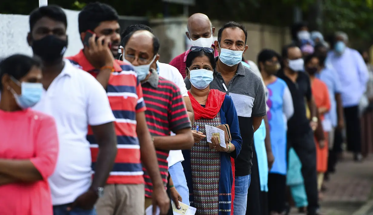 Para pemilih mengenakan masker saat antre di luar tempat pemungutan suara di Kolombo, Sri Lanka, Rabu (5/8/2020). Sri Lanka menggelar pemilihan parlemen di tengah pandemi COVID-19. (Ishara S. KODIKARA/AFP)