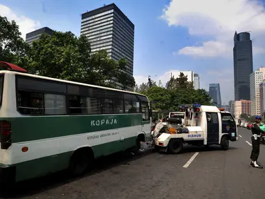 Petugas Dinas Perhubungan (Dishub) DKI Jakarta menderek bus Kopaja yang ngetem di kawasan Stasiun Sudirman, Jakarta (17/7). Razia ini digelar untuk menyambut Asian Games Agustus mendatang. (Merdeka.com/Arie Basuki)