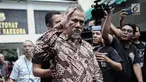 Tersangka kasus narkoba yang juga aktor senior Tio Pakusadewo menyapa awak media sebelum dibawa Kejaksaan Negeri Jakarta Selatan di Direktorat Reserse Narkoba Polda Metro Jaya, Jakarta, Selasa (3/4). (Liputan6.com/Faizal Fanani)