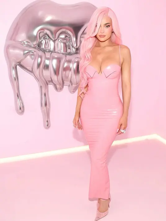 Kylie tampil dengan long dress pink latex fit body dengan strapnya. Dipadukan dengan stiletto heels warna pink. [@kyliejenner]
