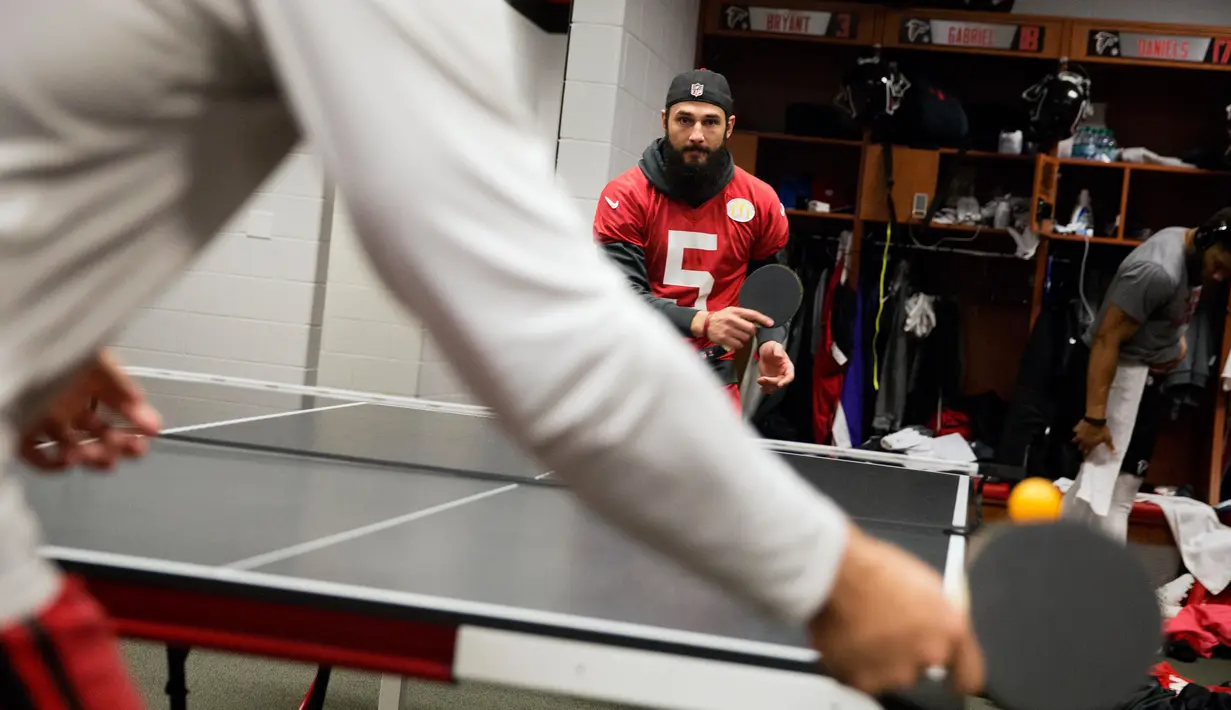 Pemain Atlanta Falcons, Matt Bosher beraksi bermain tenis meja di ruang ganti di Flowery Branch, Ga (26/1). Dengan bermain tenis meja para pemain american football ini dapat akrab dengan rekan-rekannya. (AP Photo/David Goldman)